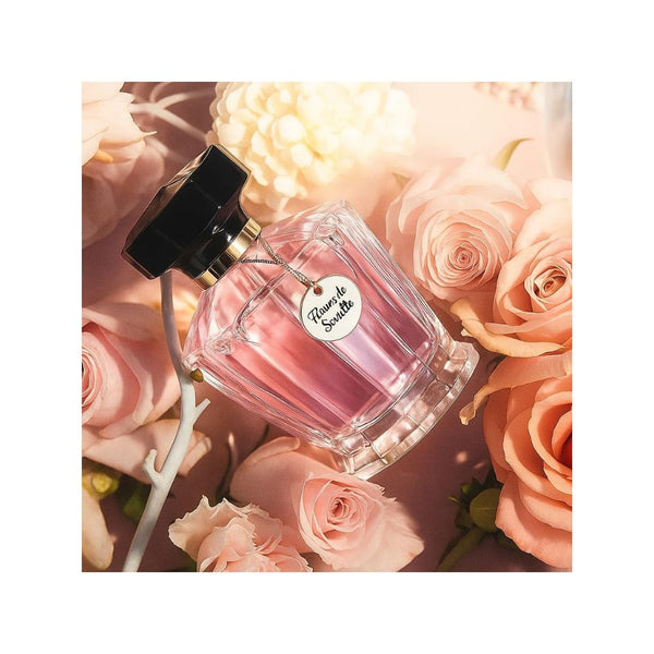 Perfume bottle with a tag on pink roses