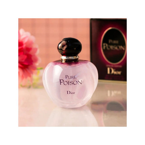 Dior Pure Poison perfume bottle with packaging on a reflective surface